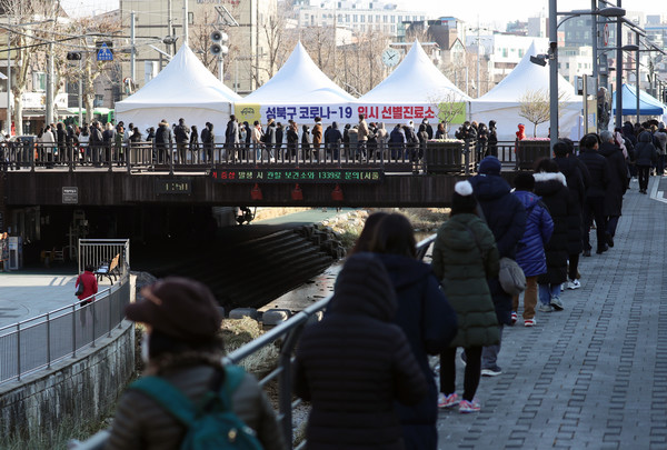 서울 성북구가 구청 내 직원 1명이 코로나19 확진 판정을 받았다고 밝힌 18일 성북구청 앞 임시선별진료소를 찾은 구청 직원 및 시민들이 검사를 위해 줄을 서고 있다. 구에 따르면 해당 확진자는 민원과 관련된 부서 소속은 아니다. 시민들에게 감염될 우려가 없는 것으로 보인다고 구는 설명했다. 2020.12.18 / 사진=[뉴시스]