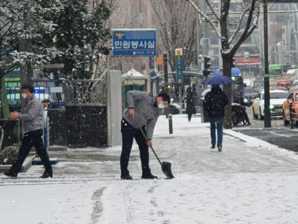 18일 서울시 종로경찰서 앞에서 갑작스러운 폭설로 인해 도로에 쌓여있는 눈을 치우고 있다. 2021.01.18