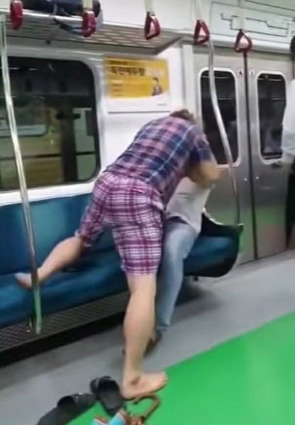 지난 27일 당산역을 지나던 서울 지하철 2호선 안에서 한 50대 남성이 마스크 착용을 요구하는 승객의 목을 조르고, 신고 있던 슬리퍼로 얼굴을 치고 있다. 2021.01.22 / 사진=[유튜브 캡쳐]