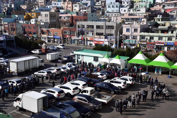 부산시는 4~8일 부산항운노조 23개 지부의 정규직과 임시직 근로자 총 9928명 명을 대상으로 전수검사를 진행하기 위해 '찾아가는 이동 선별검사소' 6곳을 운영한다고 밝혔다. 4일 오전 서구 부산공동어시장 주차장에 마련된 임시선별검사소를 찾은 항만근로자들이 길게 줄을 선 채 차례를 기다리고 있다. 2021.02.04 / 사진=[뉴시스]