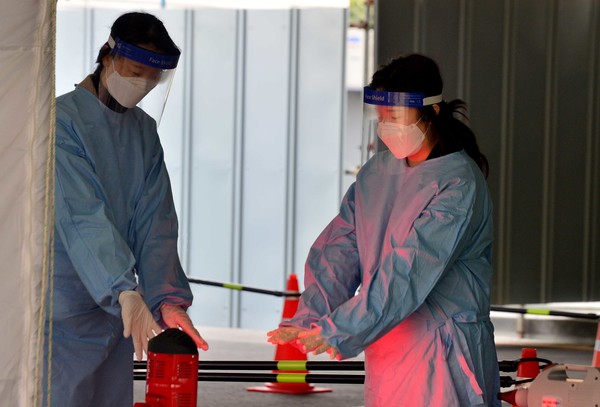 설 명절 당일인 12일 오전 광주 서구보건소 선별진료소에서 의료진이 난로 주변에서 손을 녹이고 있다. 2021.02.12 / 사진=[뉴시스]