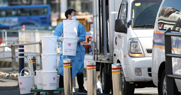 0시 기준 303명의 신규 코로나19 확진자가 발생한 9일 서울역 광장에 설치된 중구 임시 선별검사소에서 한 관계자가 의료폐기물을 처리하고 있다. 2021.02.09 / 사진=[뉴시스]