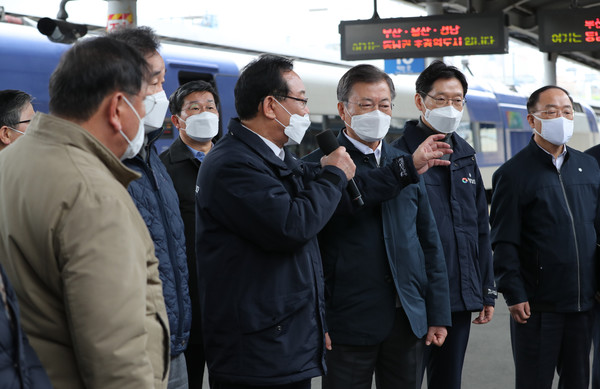 문재인 대통령이 25일 오후 부산 부산진구 부전동 부전역에서 열린 ‘동남권 메가시티 구축 전략 보고’ 행사에 참석해 송철호 울산광역시장으로부터‘동남권 광역교통망 구축’등을 골자로 하는 생활공동체 조성 방안과‘동남권 광역특별연합’이라는 행정공동체 구성 계획 발표를 듣고 있다.부전역은 동남권 메가시티 핵심 인프라인 동남권 광역철도의 요충지다. 이번 행사는 ‘한국판 뉴딜 현장을 가다’ 열한 번째 현장 행보이자,한국판 뉴딜의 핵심인‘지역균형 뉴딜 투어’로서는 두 번째 행보다. 2021.02.25 / 사진=[뉴시스]