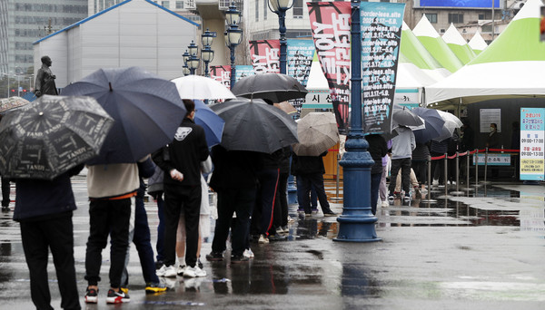 코로나19 신규 확진자가 452명으로 집계된 20일 서울역 광장에 마련된 중구 임시 선별검사소에서 시민들이 우산을 쓰고 검사를 받기 위해 줄지어 기다리고 있다. 2021.03.20 / 사진=[뉴시스]