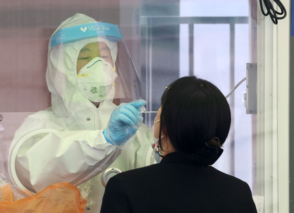 코로나19 신규 확진자가 494명으로 집계된 26일 오전 서울 중구 서울역광장에 마련된 코로나19 중구임시선별검사소에서 의료진이 검체 채취를 하고 있다. 2021.03.26 / 사진=[뉴시스]