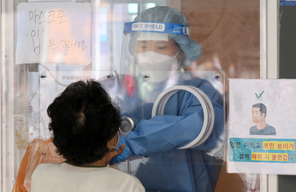 코로나19 신규 확진자가 666명으로 집계된 22일 오전 서울 중구 서울역광장에 마련된 코로나19 중구임시선별검사소에서 의료진이 검체 채취를 하고 있다. 2021.05.22 / 사진=[뉴시스]