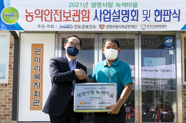 왼쪽부터 생명보험사회공헌재단 송기정 상임이사와 관마마을 김영화 이장이 농약안전보관함 현판식에서 기념 촬영을 하고 있다