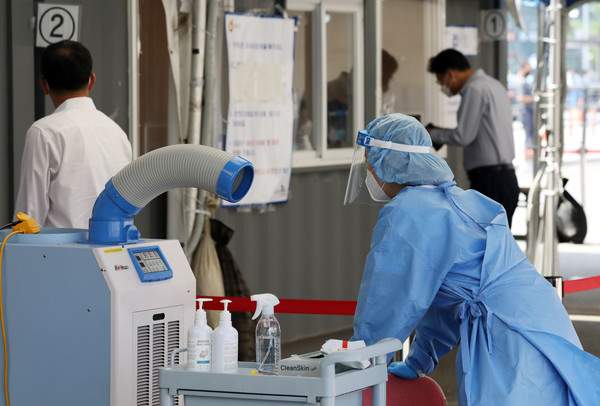 코로나19 신규 확진자가 357명으로 집계된 21일 오전 서울 중구 서울역광장에 마련된 코로나19 중구임시선별검사소에서 의료진이 에어컨 바람을 쐬고 있다. 2021.06.21 / 사진=[뉴시스]