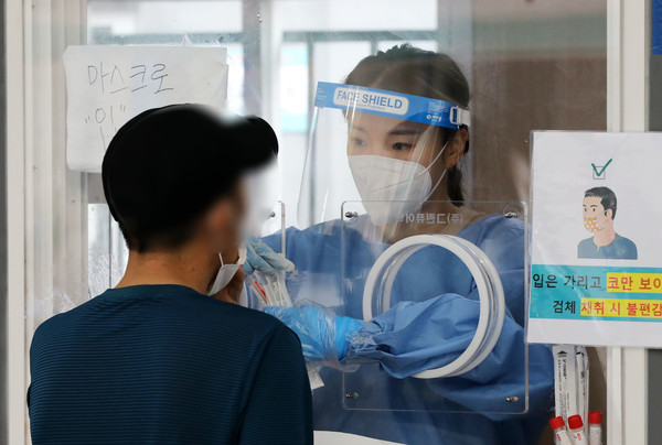 코로나19 신규 확진자가 711명으로 집계된 5일 오전 서울 중구 서울역광장에 마련된 코로나19 중구임시선별검사소에서 의료진이 검체 채취를 하고 있다. 2021.07.05 / 사진=[뉴시스]