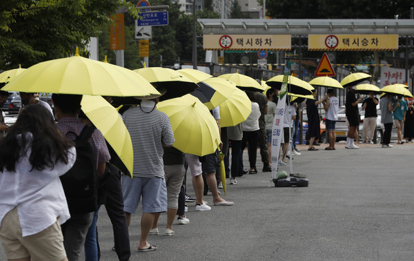 0시 기준 국내 코로나19 신규 확진자가 1615명을 기록하고 있는 14일 서울 서초구 고속버스터미널 임시선별검사소를 찾은 시민이 노란 우산을 쓰고 검사를 기다리고 있다. 2021.07.14 / 사진=[뉴시스]