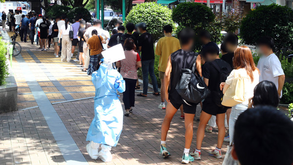 코로나19 사태 이후 부산에서 하루 최다 규모인 97명의 확진자가 발생한 20일 동래구 보건소 선별진료소를 찾은 시민들이 진단검사를 받기 위해 길게 줄을 선 채 차례를 기다리고 있다. 2021.07.20 / 사진=[뉴시스]