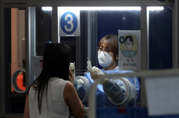 폭염이 이어진 22일 오후 서울 관악구보건소에 마련된 선별진료소에서 의료진이 코로나19 검사를 하고 있다.2021.07.22 / 사진=[뉴시스]