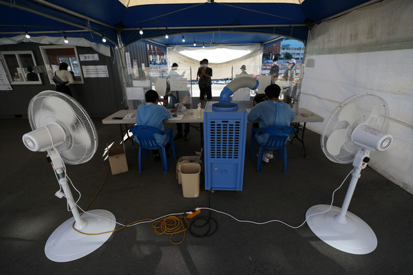 0시 기준 1318명의 신규 코로나 확진자가 발생한 26일 오전 서울역광장에 설치된 임시선별검사소에서 현장 관계자들이 에어컨과 선풍기 바람을 쐬며 업무를 진행하고 있다. 2021.07.26 / 사진=[뉴시스]