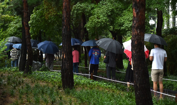 비가 내리고 있는 24일 대구 중구 국채보상운동기념공원 코로나19 임시선별검사소에서 시민들이 검사를 받기 위해 우산을 쓰고 긴 줄을 서고 있다. 2021.08.24 / 사진=[뉴시스]