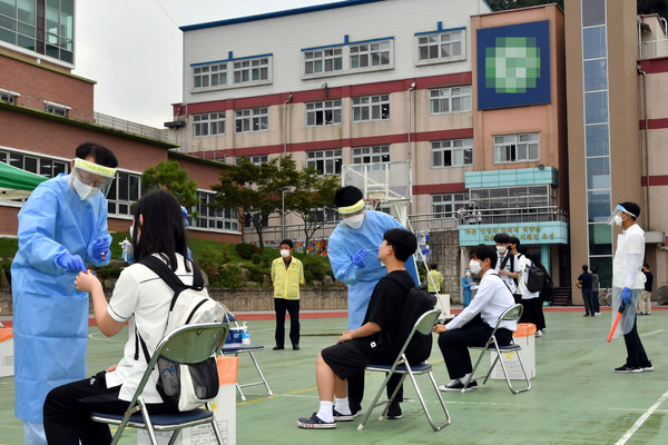 30일 오전 강원 화천군 B 고등학교 학생들이 학교에 설치된 임시 선별검사소에서 코로나19 진단검사를 받고 있다. A 고등학교에서 시작된 집단감염 사태가 인근 고등학교·초등학교로 확산되고 있다.2021.08.30 / 사진=[화천군청 제공]