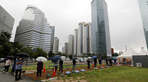 7일 오전 서울 용산역에 마련된 임시선별진료소에서 우산을 쓴 시민들이 코로나19 검사를 받기 위해 길게 줄지어 서 있다. 2021.09.07.