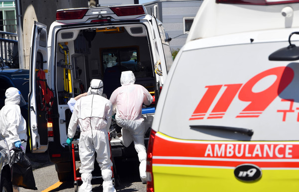 7일 집단감염이 발생한 부산 기장군의 한 요양병원에서 119구급대가 확진 환자를 이송하고 있다. 이 요양병원에서는 종사자 4명과 환자 34명 등 38명이 확진 판정을 받았으며, 이 중 34명이 백신 2차 접종까지 마친 돌파감염 사례라고 부산시는 전했다. 2021.08.07.