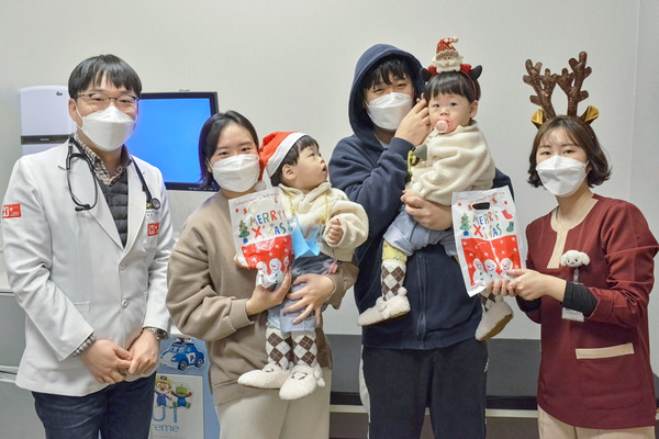 ▲H+ 양지병원 소아청소년과 양무열 과장(왼쪽)이 병원을 찾은 어린이 환자들에게 선물을 나눠주고 기념촬영을 하고 있다. (사진=H+ 양지병원)
