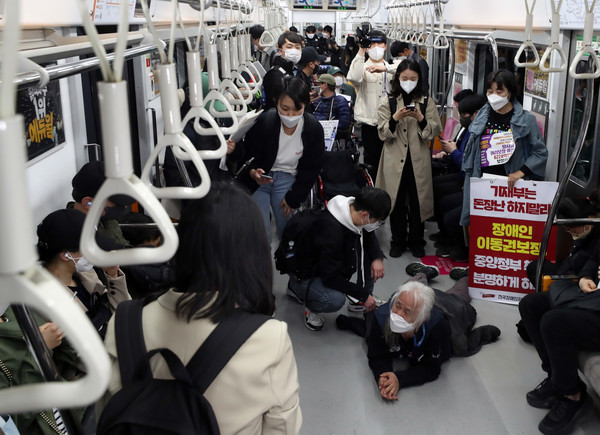 박경석 전국장애인차별철폐연대(전장연) 공동대표와 회원들이 21일 서울 종로구 지하철3호선 경복궁역에서 '출근길 지하철 타기' 시위를 하고 있다. 전장연에 따르면 시위는 이날 오전 7시부터 서울 지하철 3호선 경복궁역, 2호선 시청역, 5호선 광화문역 등 3곳에서 동시 진행된다. 2022.04.21 / 사진=[뉴시스]