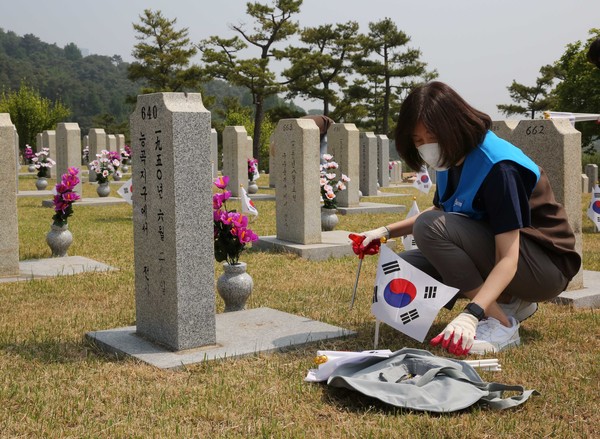 GS리테일 임원이 묘비 정비를 하고 있다 (사진 = GS리테일 제공)
