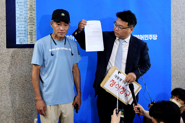서해 피살 공무원의 형 이래진(왼쪽) 씨와 법률대리인 김기윤 변호사가 27일 오전 서울 여의도 국회 더불어민주당 대표실 앞에서 우상호 민주당 비상대책위원장과의 비공개 면담에 앞서 취재진에게 '대통령기록물 공개' 요청안을 설명하고 있다.2022.06.27 / 사진=[공동취재사진]