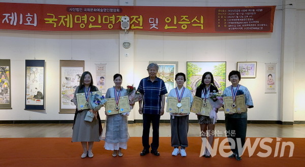 제1회 국제 명인명장전 및 인증식에서 민화 부문 명인 인증을 받고 기념촬영을 하고 있다(사진=정경호 기자)