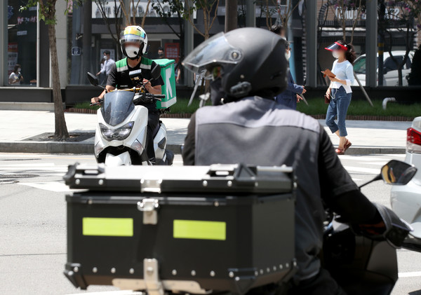 서울 시내에서 배달종사자가 신호를 기다리고 있다 (사진 출처 = 뉴스인DB)