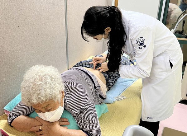 [사진설명] 부천자생한방병원 의료진이 임시진료소를 방문한 환자에게 침 치료를 실시하고 있다