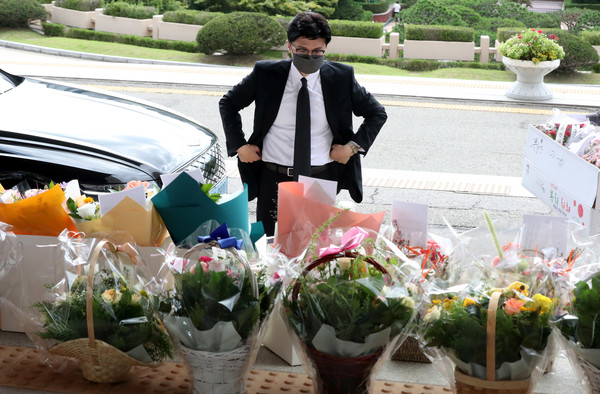 한동훈 법무부 장관이 24일 오전 경기 과천시 정부과천청사에서 출근하며 취임 100일을 맞아 지지자들이 보낸 꽃다발을 살펴보고 있다. 2022.08.24 / 사진=[뉴시스]