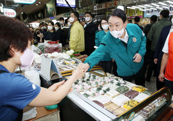 윤석열 대통령이 25일 서울 강동구 암사종합시장을 방문해 떡을 구매하고 있다. 2022.08.25 / 사진=[뉴시스]