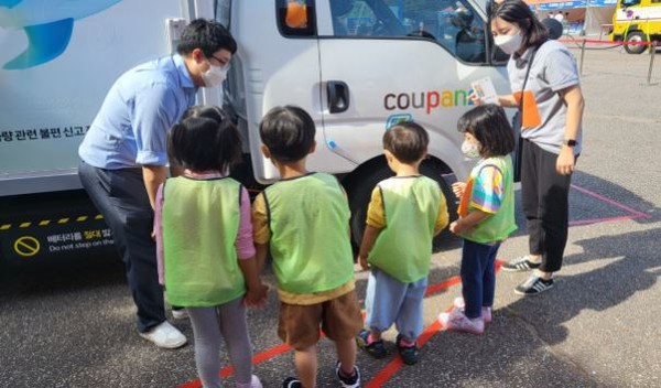 쿠팡 배송차량 주변에서 화물차 사각지대를 체험하는 어린이들(한국교통안전공단 사진 제공)