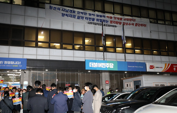 19일 서울 여의도 더불어민주당사 앞에서 압수수색을 시도하는 검찰과 민주당 관계자들이 대치하는 가운데 당사 외벽에 검찰의 압수수색을 규탄하는 현수막이 걸려있다. 검찰은 이날 정치자금법 위반 혐의로 체포된 김용 민주연구원 부원장과 관련해 더불어민주당사 내에 위치한 민주연구원 압수수색에 나섰다 / 사진=[뉴시스]