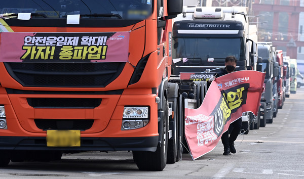 화물연대가 총파업을 철회한 9일 오후 경기도 의왕시 내륙컨테이너기지(ICD)앞 도로에 주차된 화물차에서 한 조합원이 현수막을 철거하고 있다. 2022.12.09 / 사진=[뉴시스]
