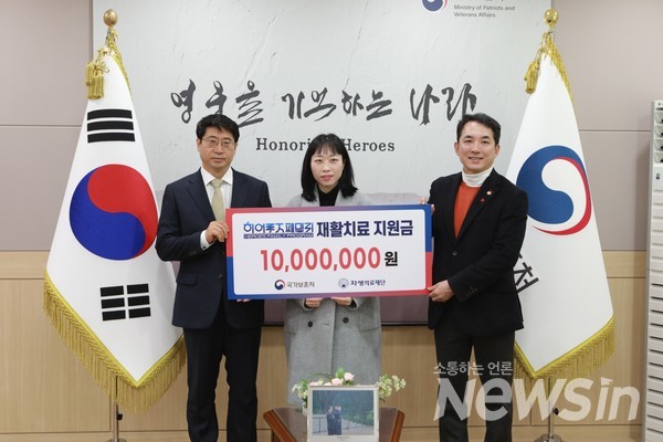 자생의료재단 신민식 사회공헌위원장(왼쪽)과 국가보훈처 박민식 처장(오른쪽)이 고(故) 유재국 경위 배우자에게 지원금을 전달하고 있다