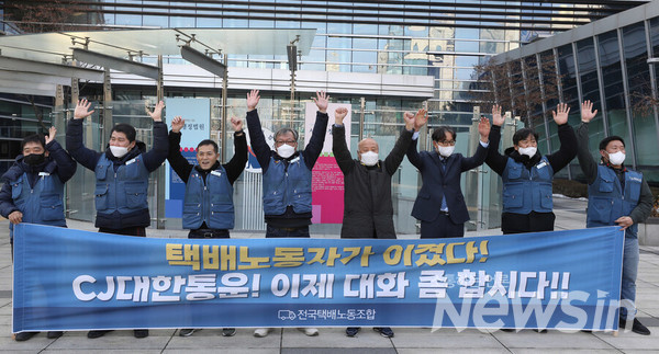 전국택배노동조합 대표들과 민주노총 법률원 변호사, 시민단체 대표들이 12일 오후 서울 서초구 행정법원 정문앞에서 CJ대한통운이 택배기사들과의 단체교섭을 거부한 것은 부당노동행위라는 판결에 환영하며 만세를 부르고 있다. 