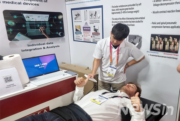 CES 2023 참가자가 휴스파인의 부스에서 AI 척추 감압 견인기를 체험하고 있다.