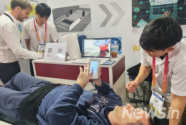 CES 2023 참가자가 휴스파인의 부스에서 AI 척추 감압 견인기를 체험하고 있다.