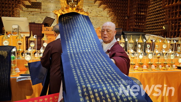 법화정사 석도림 스님이 기증받은 사경(寫經)한 법화경을 펼쳐 보이고 있다(사진=정경호 기자)