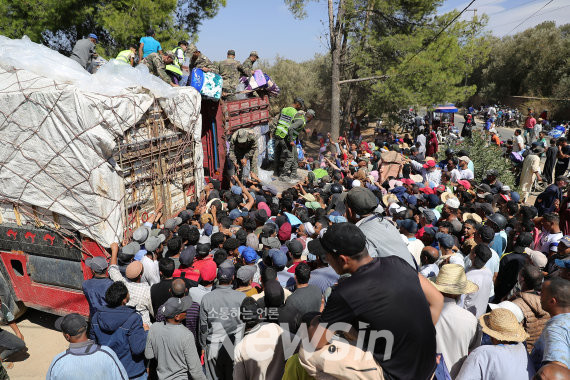 ▲11일(현지시간) 모로코 마라케시 남부 아미즈미즈의 지진 피해 현장에서 구조대가 이재민들에게 구호 물품을 나눠주고 있다. (사진=신화통신)