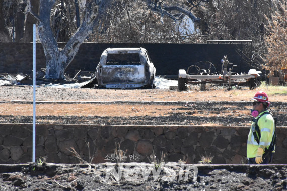 ▲지난달 22일(현지시간) 미 하와이주 라하이나 산불 피해 지역에서 한 관계자가 복구 작업을 하고 있다. . (사진=신화통신)