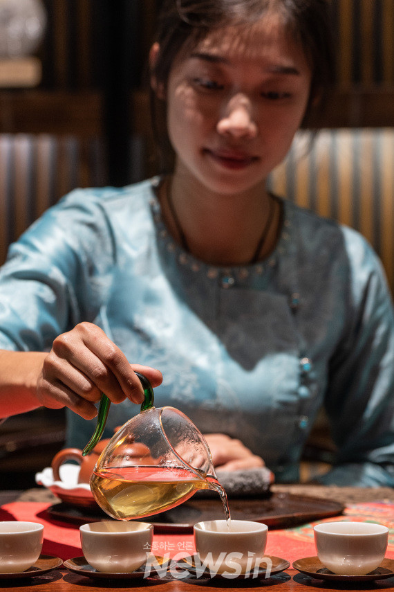 ▲징마이산 부랑궁주(公主)차 공장에서 부랑족 주민이 손님에게 대접할 차를 우려내고 있다.