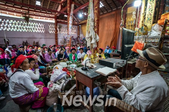 ▲징마이산 망징촌 문화활동실에서 여든에 가까운 부랑족 노인(오른쪽)이 주민들에게 생태 및 문화 보호 지식을 소개하고 있다.