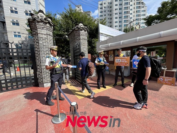하교하는 학생들을 대상으로 교통안전 거리 게릴라 캠페인을 전개하는 교통경찰 모습 