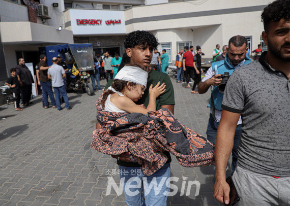 ▲17일(현지시간) 한 남성이 가자지구 알아흘리 병원 폭격으로 부상한 어린이를 가자시티 알시파 병원으로 옮기고 있다. (사진=신화통신)
