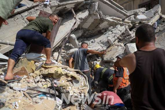 ▲24일(현지시간) 가자지구 남부 도시 칸 유니스에서 팔레스타인 주민들이 이스라엘 공습으로 파괴된 건물잔해 속 생존자를 찾고 있다. (사진=신화통신)