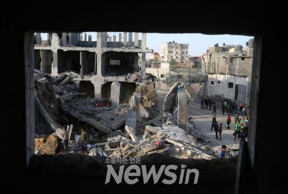 ▲지난 4일(현지시각) 가자지구 최남단 도시 라파에서 팔레스타인 주민들이 이스라엘 공격으로 파괴된 건물 잔해를 살펴보고 있다. (사진=신화통신)