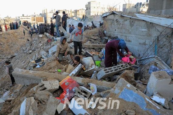 ▲지난 20일(현지시간) 가자지구 중부 누세이라트 난민캠프에서 팔레스타인 사람들이 이스라엘군의 공습으로 인한 피해 상황을 살펴보고 있다. (사진=신화통신)