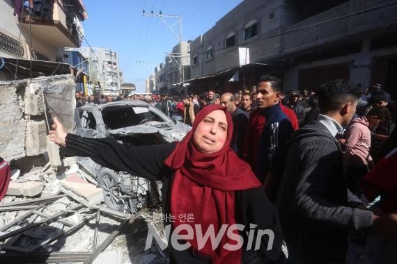 ▲지난 24일(현지시간) 가자지구 남부 라파에서 이스라엘의 공습을 받은 건물 앞에 사람들이 모여 있다. (사진=신화통신)