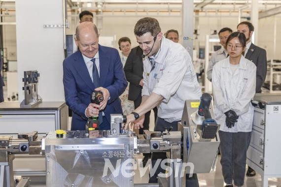 ▲올라프 숄츠 독일 총리가 14일 충칭시 주룽포구에 있는 보쉬 수소동력시스템을 방문해 둘러보고 있다. (사진=신화통신)