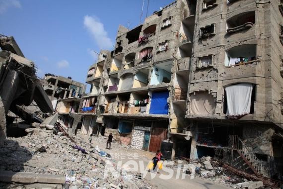 ▲1일(현지시간) 가자지구 남부 라파에서 한 어린이가 파괴된 건물 앞을 지나고 있다. (사진=신화통신)
